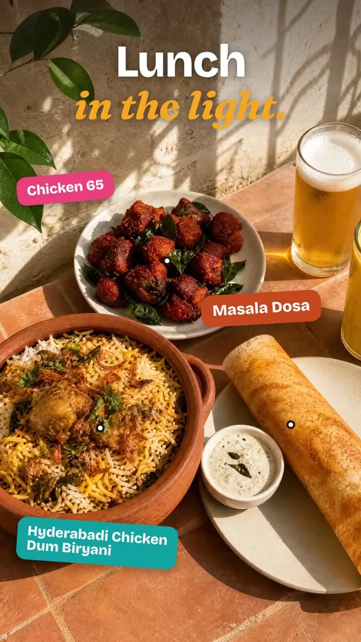 Vibrant brand ad: a sunlit lunch of Chicken 65, masala dosa and Hyderabadi chicken dum biryani, Indian single malts, and happy hour at the bar.